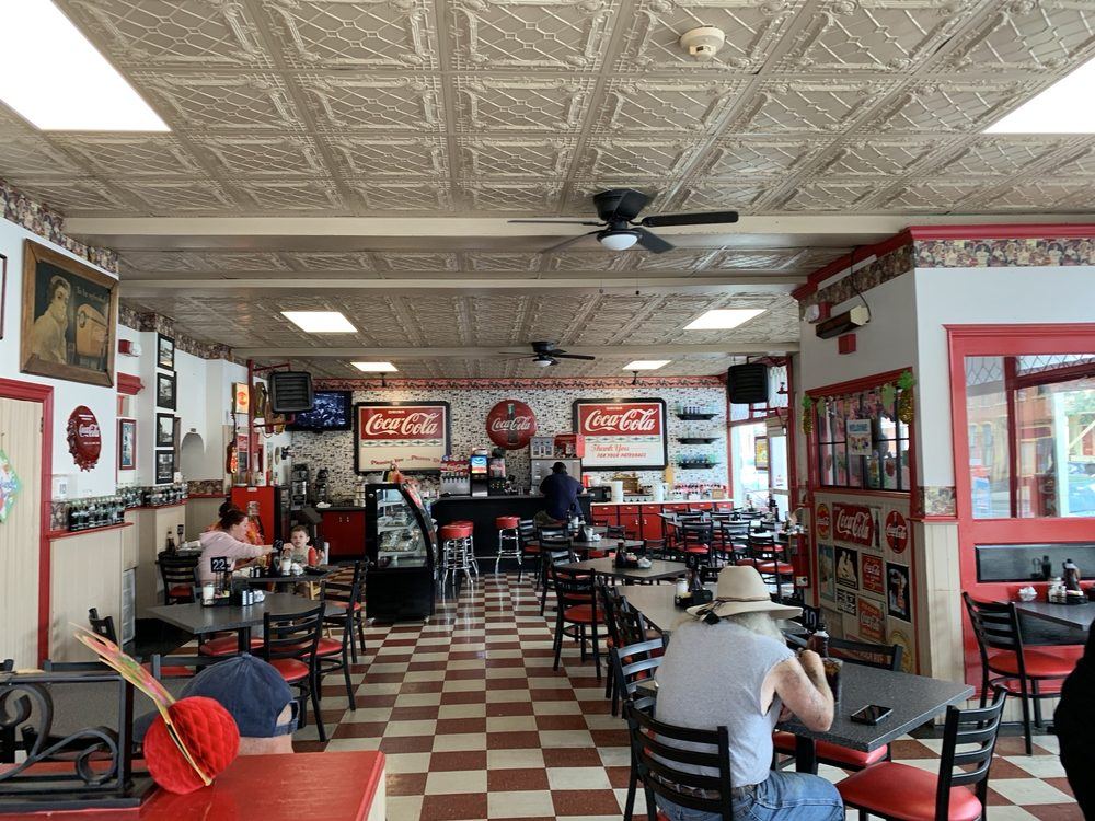 The dining room with red-and-white checkerboard floor, pressed-tin ceiling and Coca-Cola signs